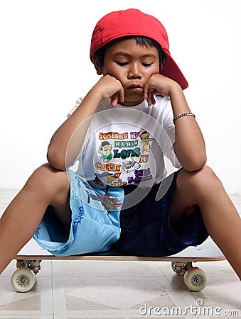 sad-little-boy-sitting-on-his-skateboard-thumb188370.jpg