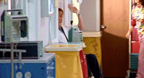 Dr.-Cox-Waves-Goodbye-In-A-Wheelchair-On-Scrubs.gif